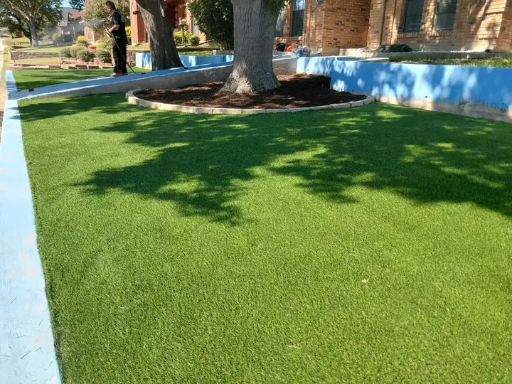 Artificial grass meeting the existing tree border at a Moriah project