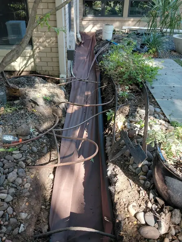 Open drainage trench running beside a home