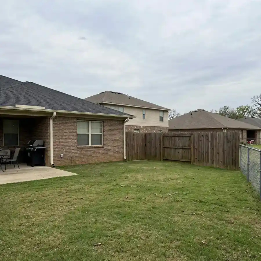 The same backyard after the damaged tree was removed and the lawn cleared